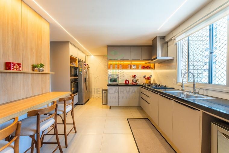 Cozinha com marcenaria planejada e bancada com banquetas
